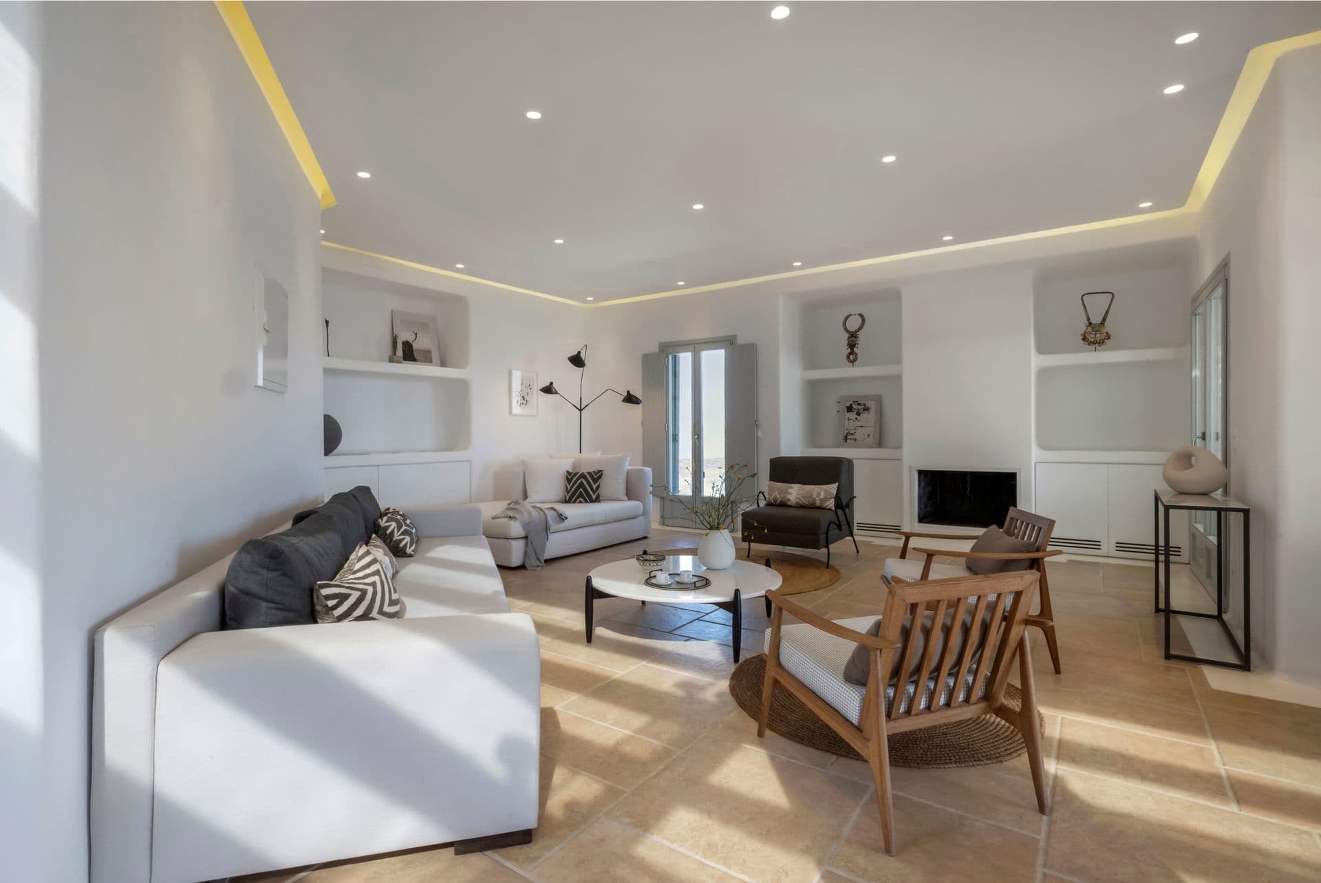 Bright indoor living room with white sofas, armchairs and decorative wall art