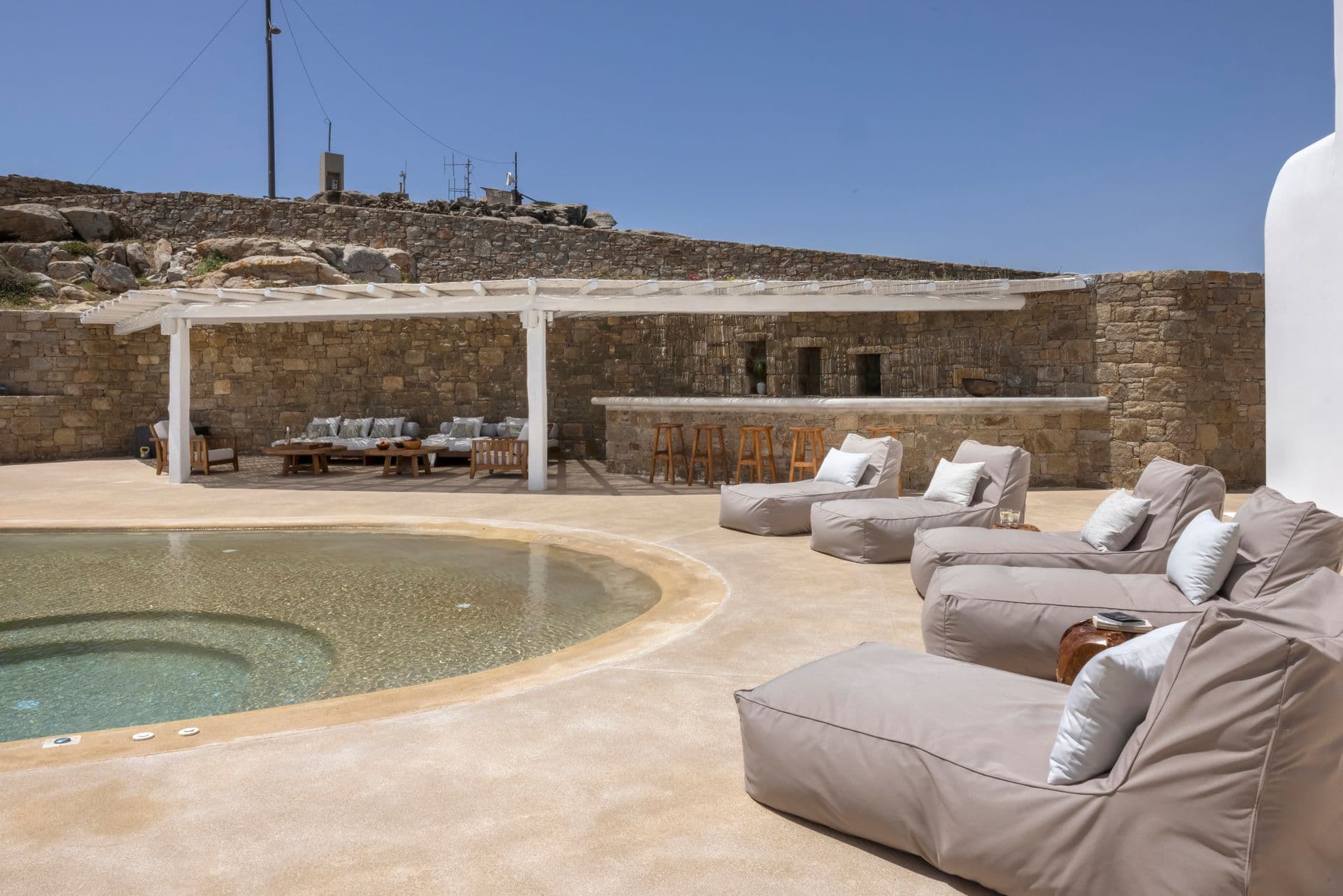 Sunken jacuzzi beside an oversized outdoor daybed lounge area