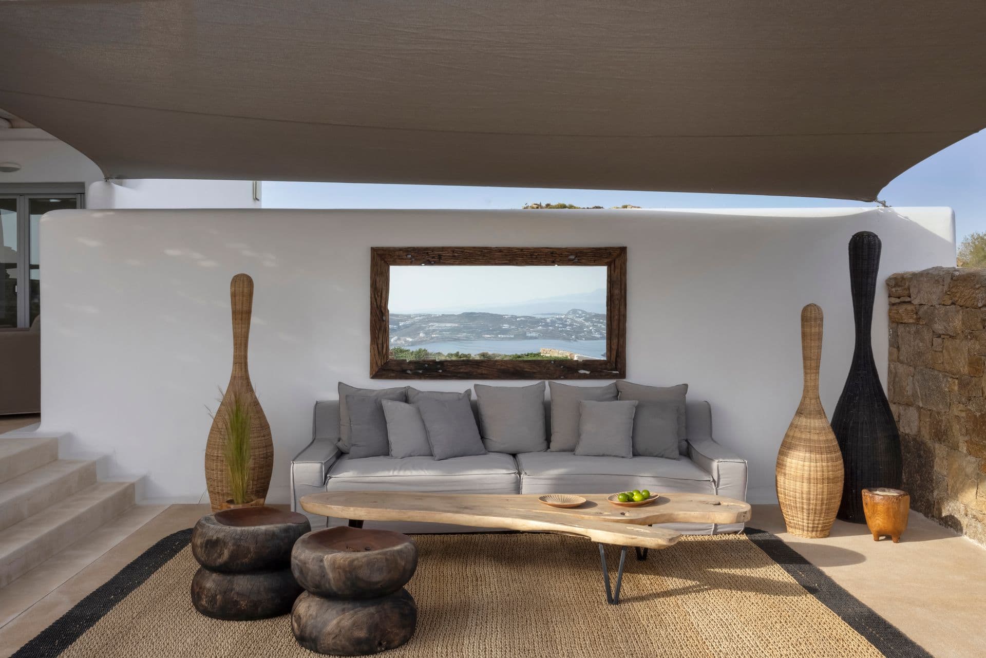 Sunken living room with sofas, decorative urns and a sea-view mirror feature