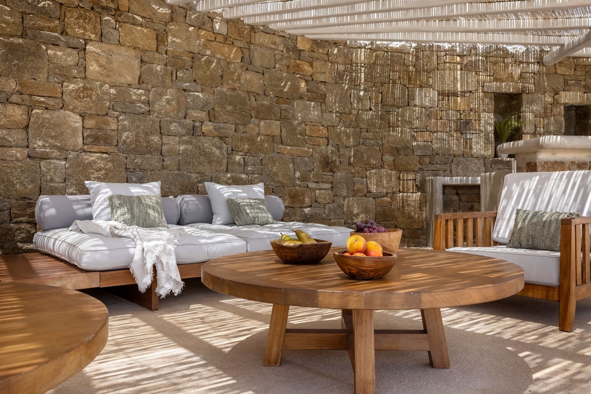 Outdoor lounge with sofa seating around a round wooden coffee table