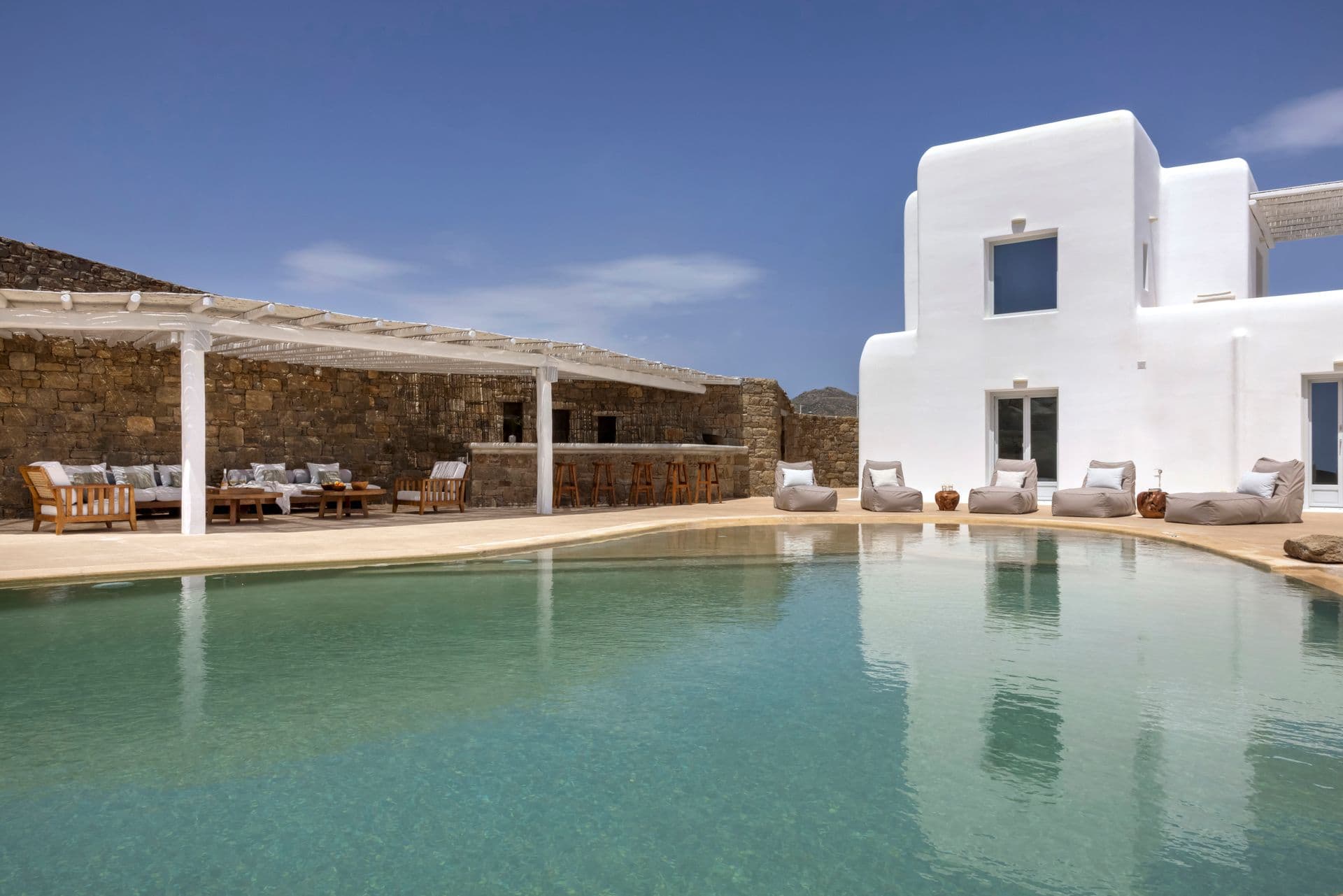 Wide turquoise pool bordered by a traditional dry stone wall