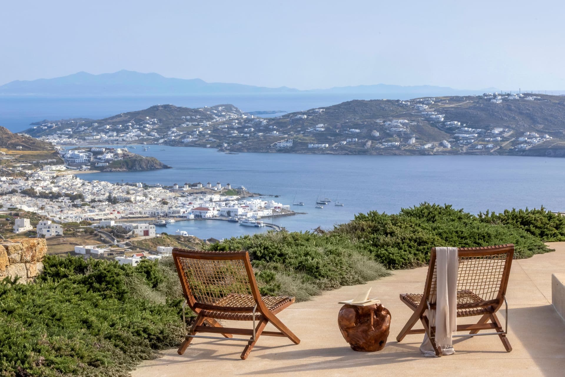 Terrace with lounge chairs overlooking Mykonos town and the Aegean Sea