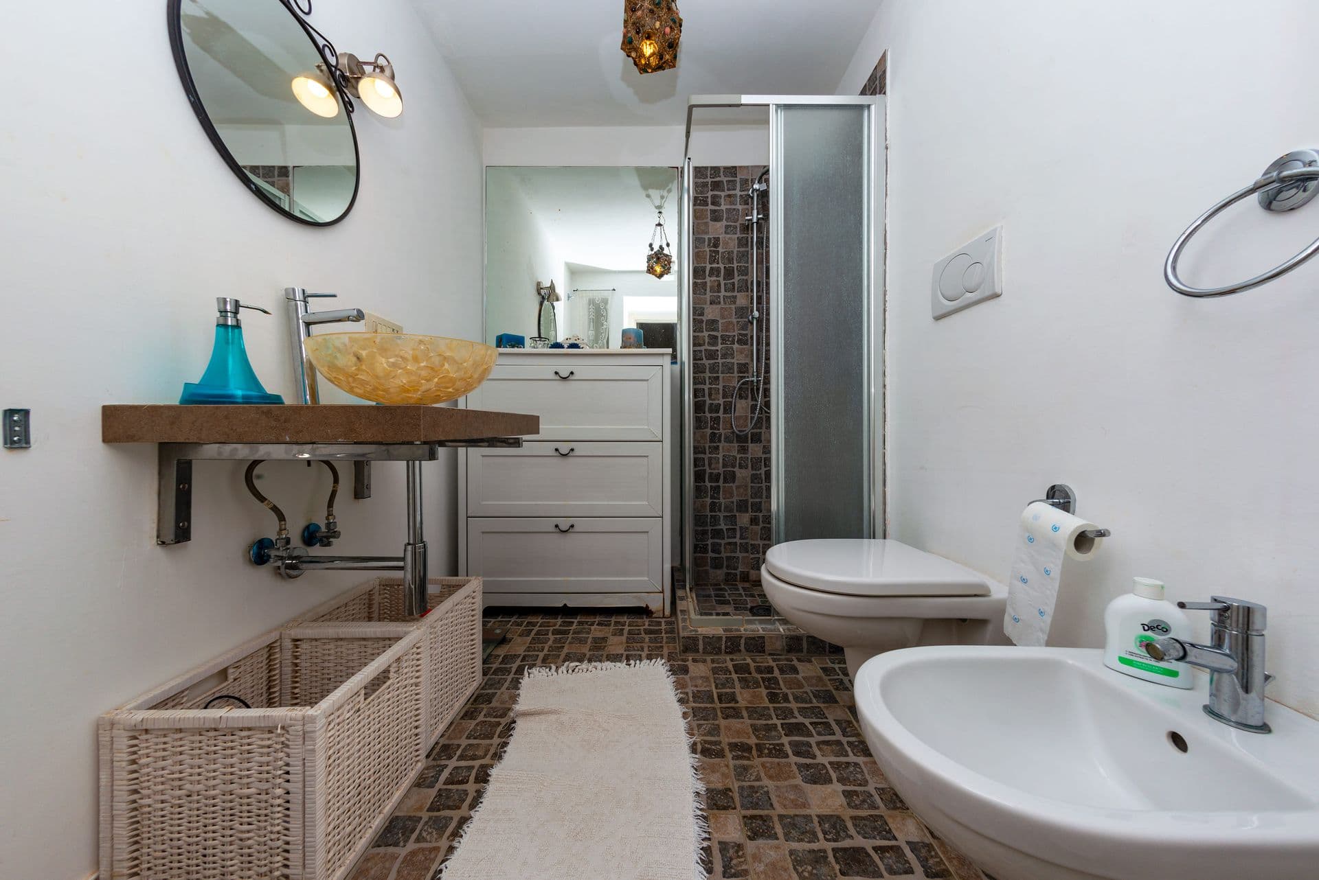 Bathroom with a corner shower and turquoise accents at Faraglioni Frills, Capri