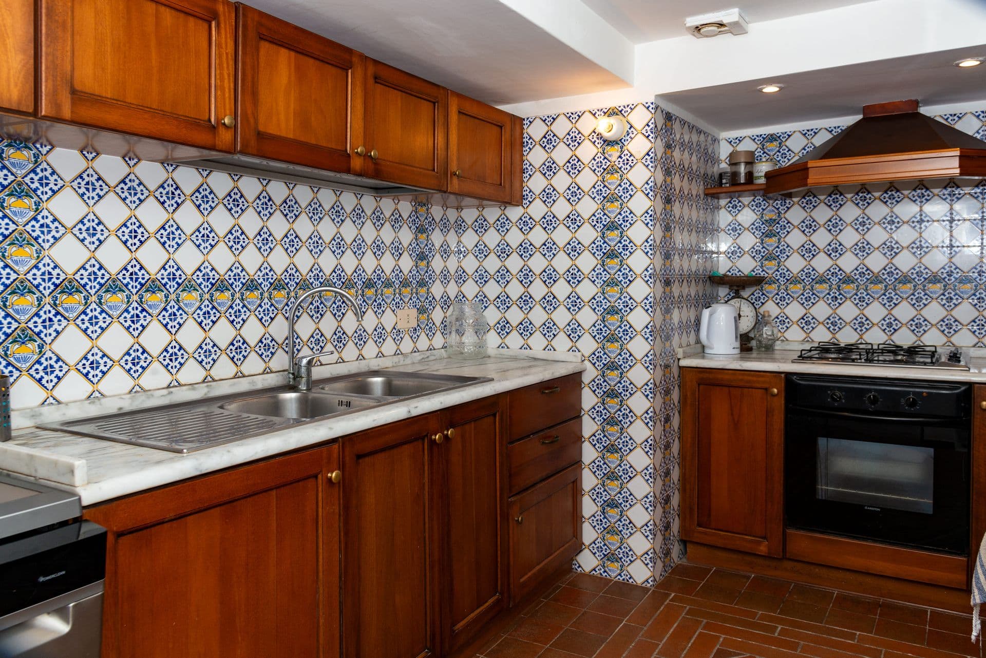 Timber kitchen with a blue-and-white majolica tiled splashback at Faraglioni Frills, Capri