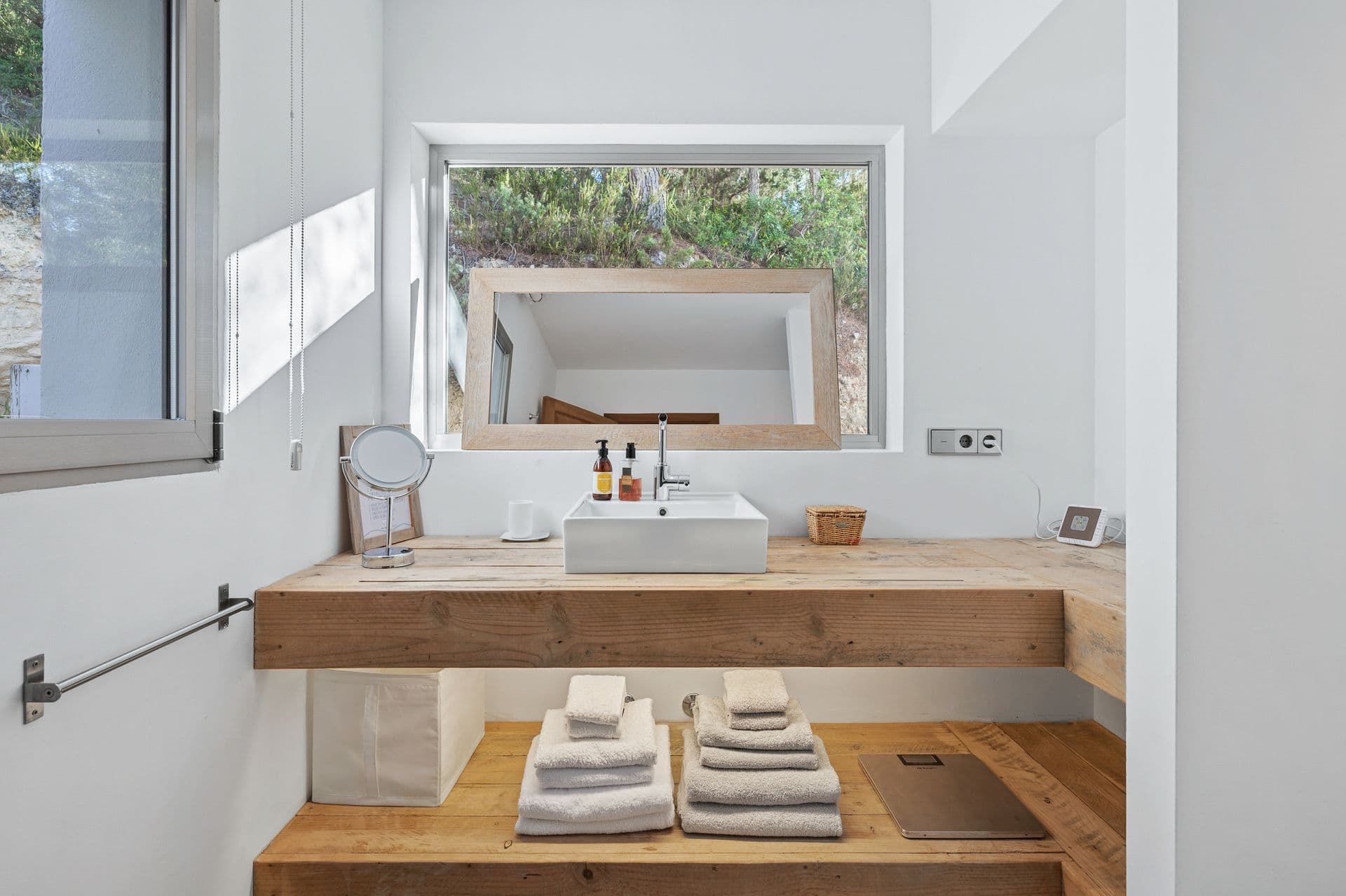 Bathroom with a reclaimed wood double vanity and folded white towels.