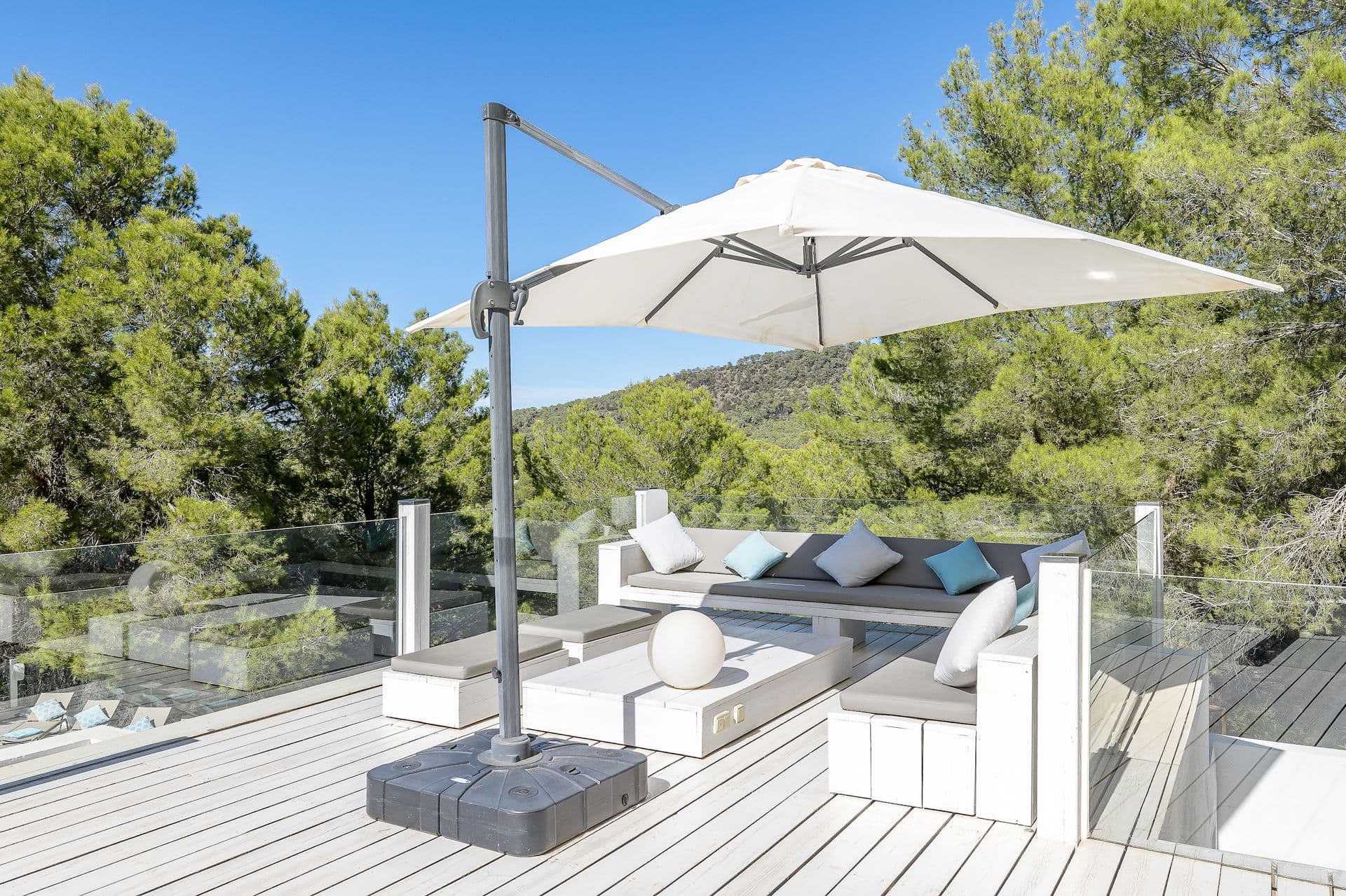 Shaded terrace lounge with sofas beneath a retractable parasol.