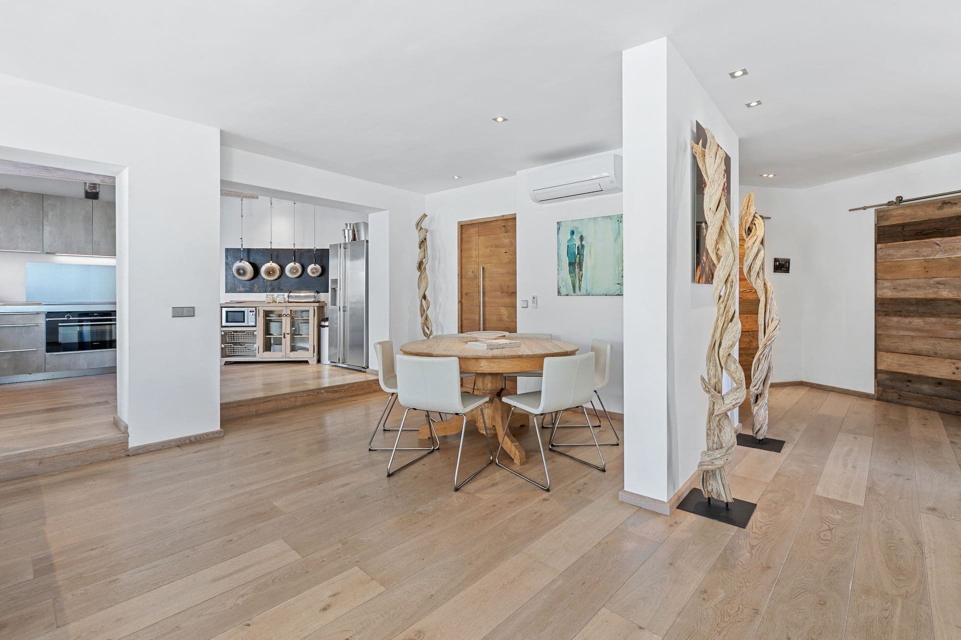 Kitchen and dining area with light oak flooring and a round dining table.