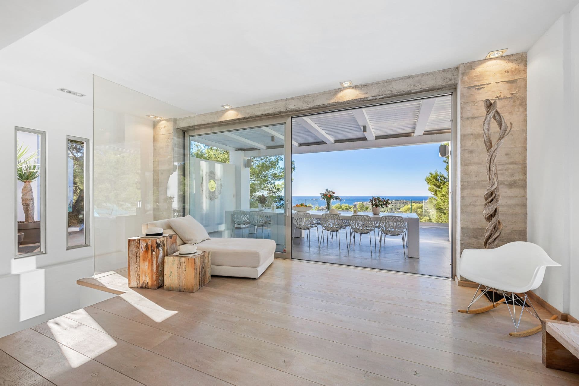 Open plan living space flowing into the dining area through sliding glass doors.