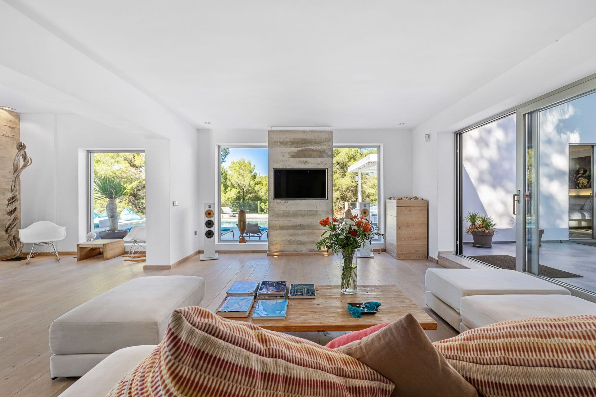 Living room with sofas positioned to look straight out over the pool.
