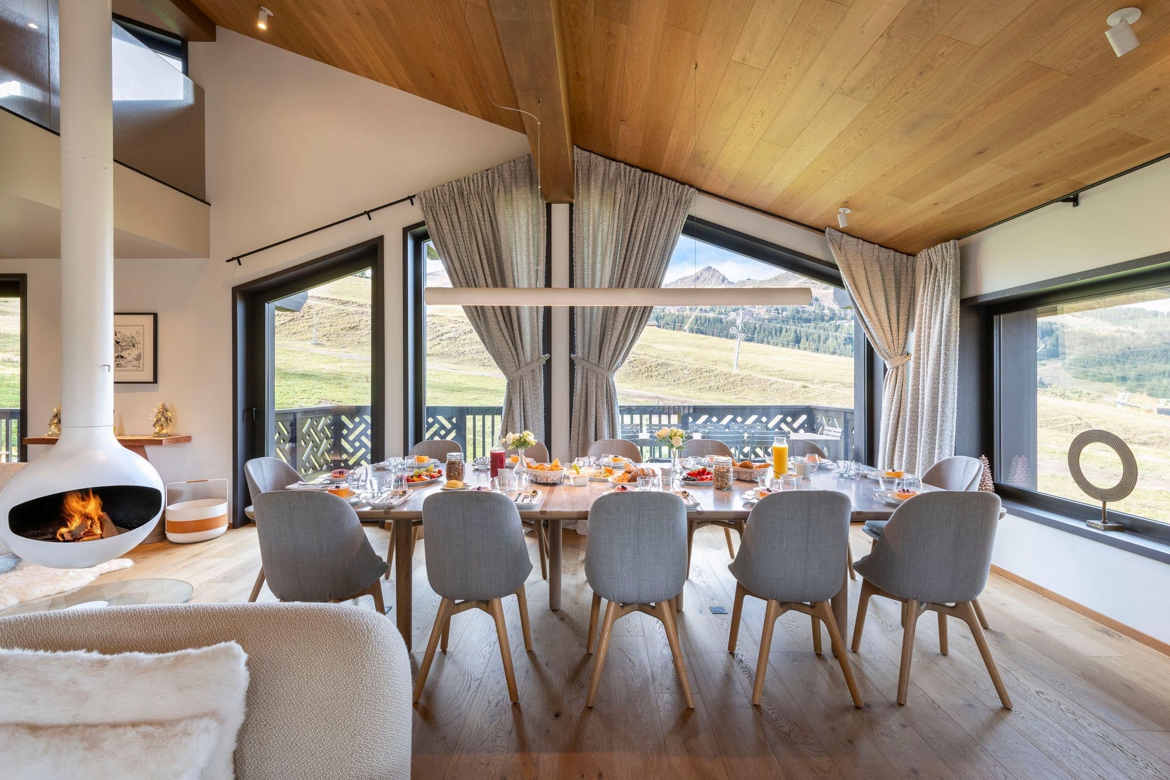 Chalet Ascension formal dining room with suspended fireplace, Courchevel 1650, French Alps, France