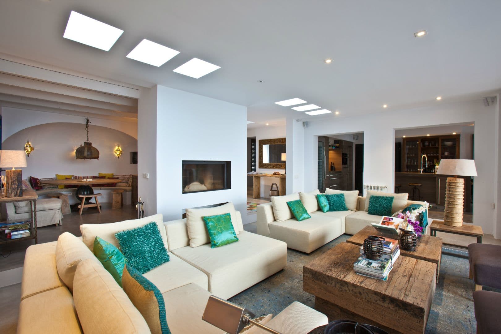 Open living space with a fireplace flowing through to the kitchen and dining area at Cicadas Sway, Ibiza