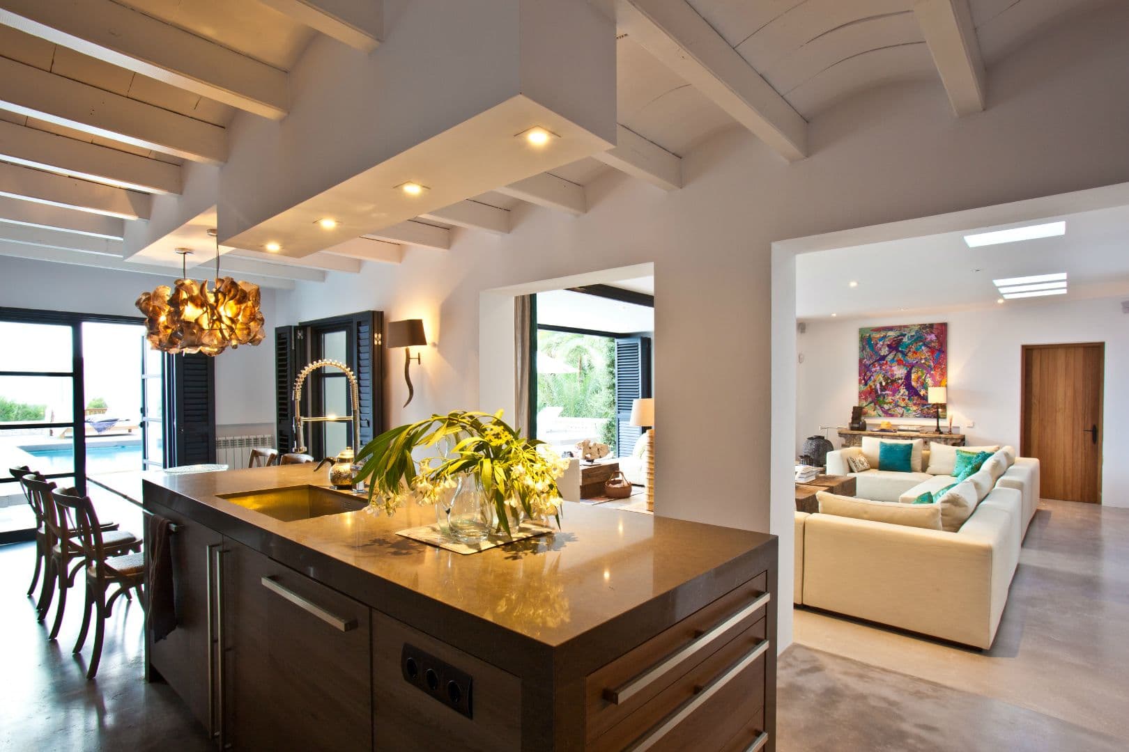 Kitchen with a timber-topped island open to the living room at Cicadas Sway, Ibiza