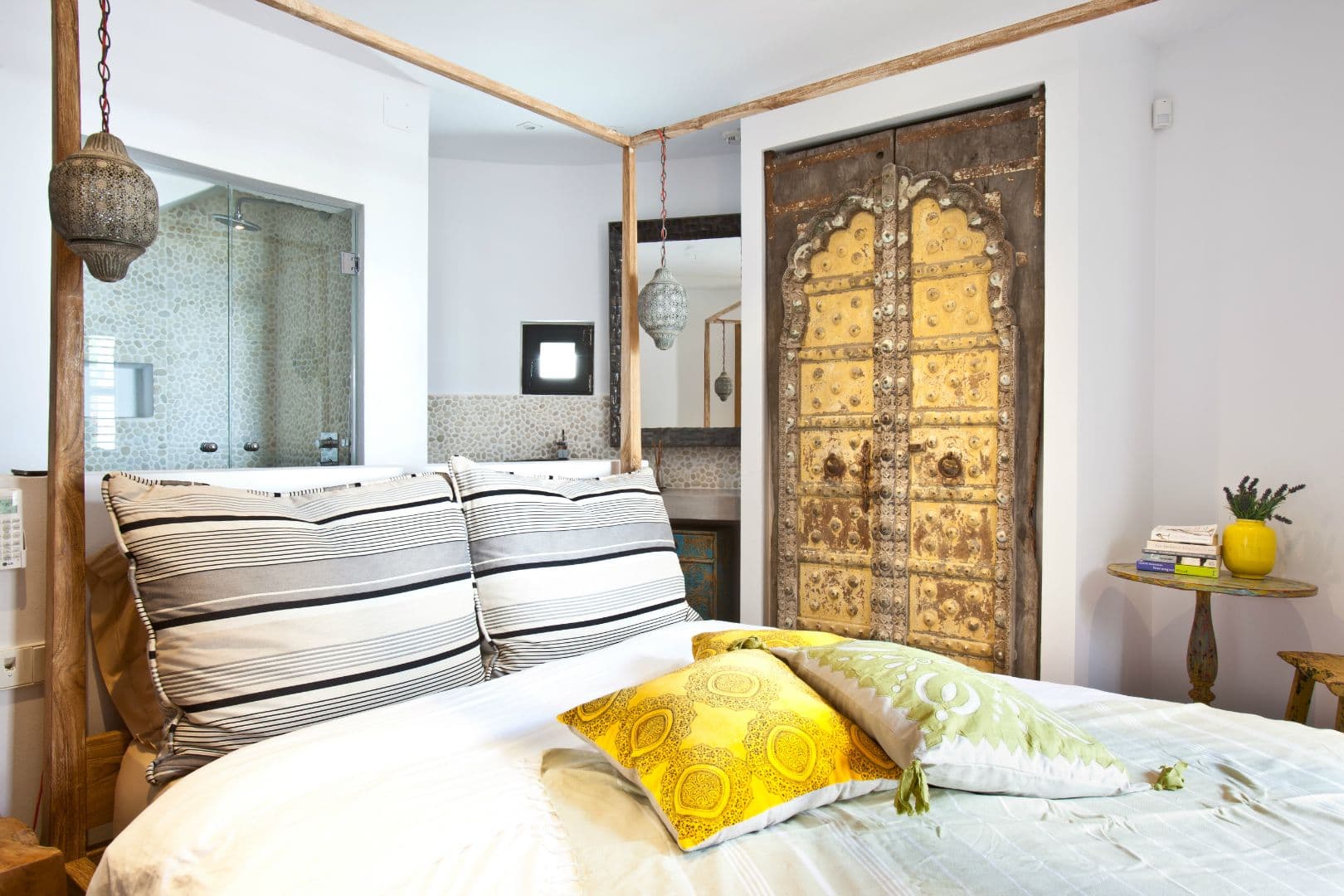 Master bedroom with a carved Indian door headboard and open en-suite at Cicadas Sway, Ibiza
