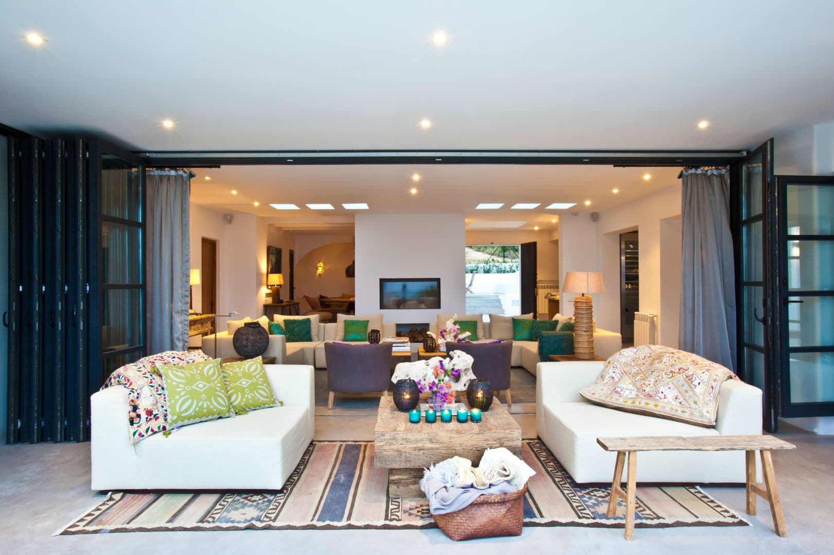 Sitting room with cream sofas, a kilim rug and fireplace at Cicadas Sway, Ibiza