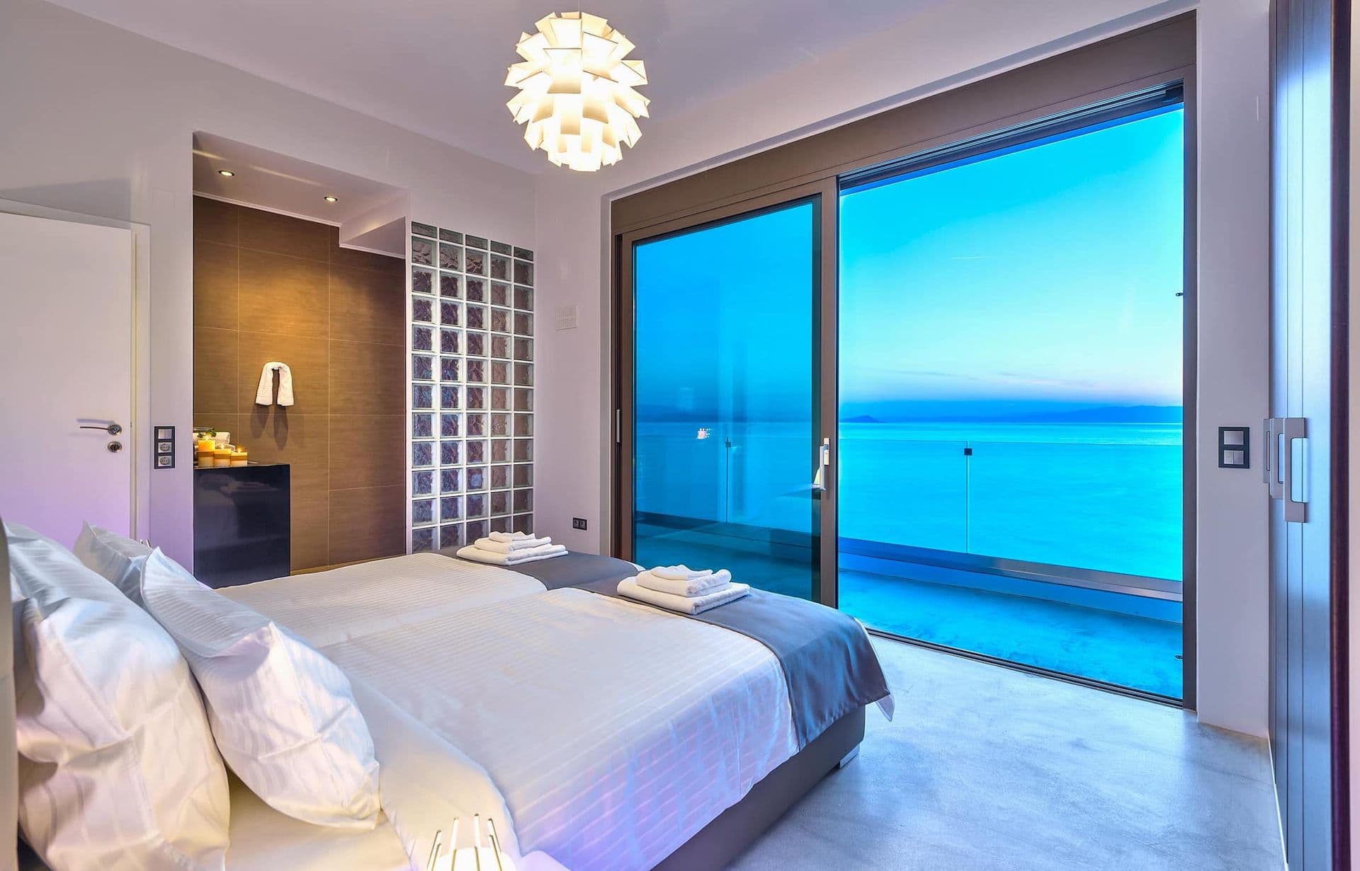 Bedroom with framed wave artwork and an en-suite bathroom beyond.