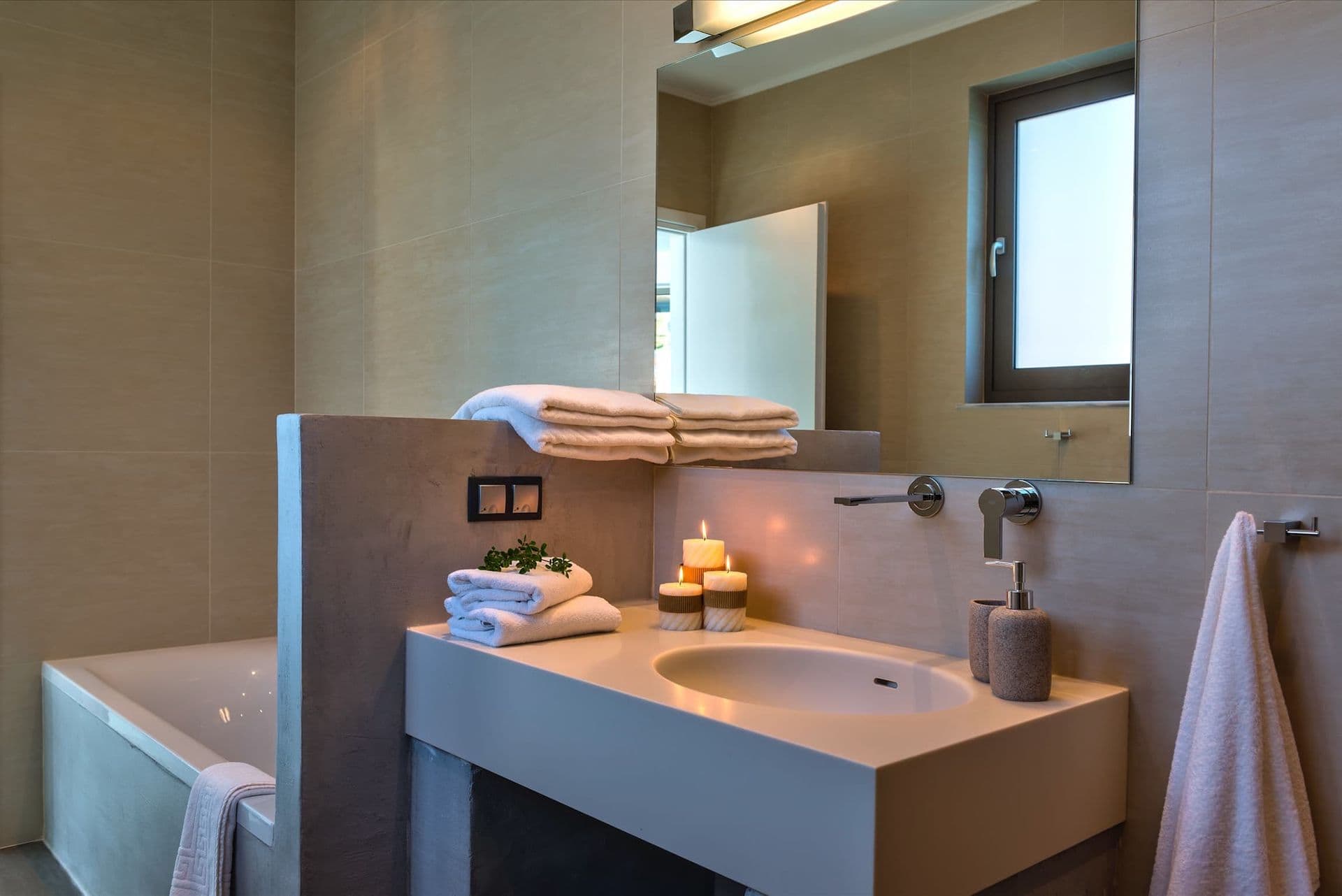 Bedroom with a mosaic tile feature wall and grey upholstered bed.