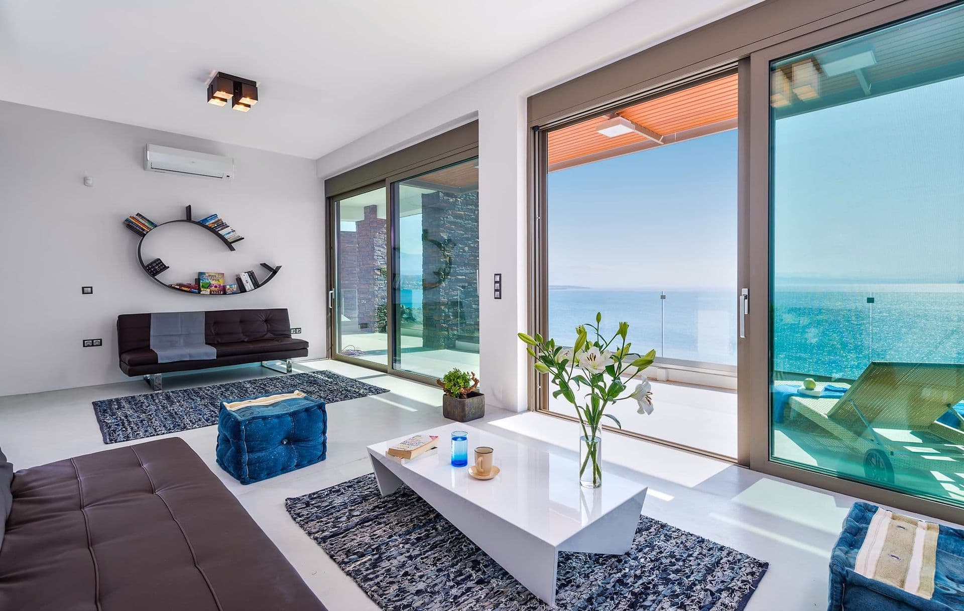 Second lounge area with a wave-shaped wall sculpture and panoramic sea views.