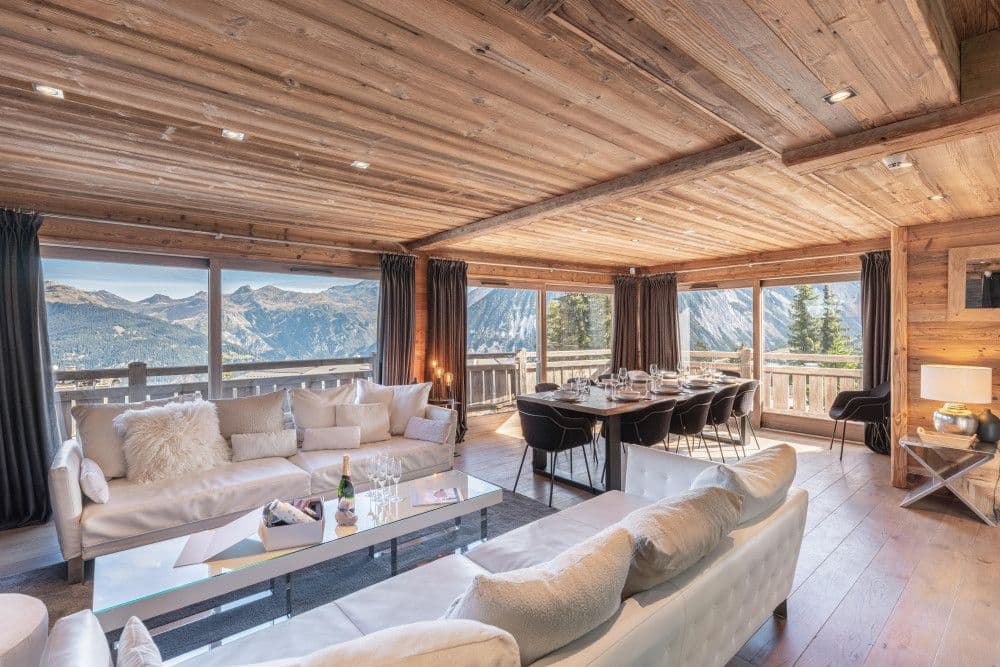Living and dining room with panoramic mountain windows at Courchevel 26
