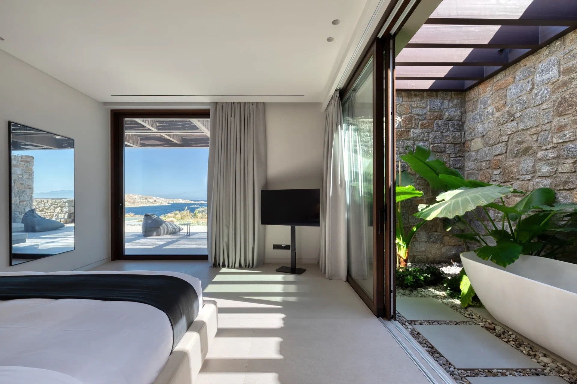 Bedroom opening directly onto a private terrace with tropical planting