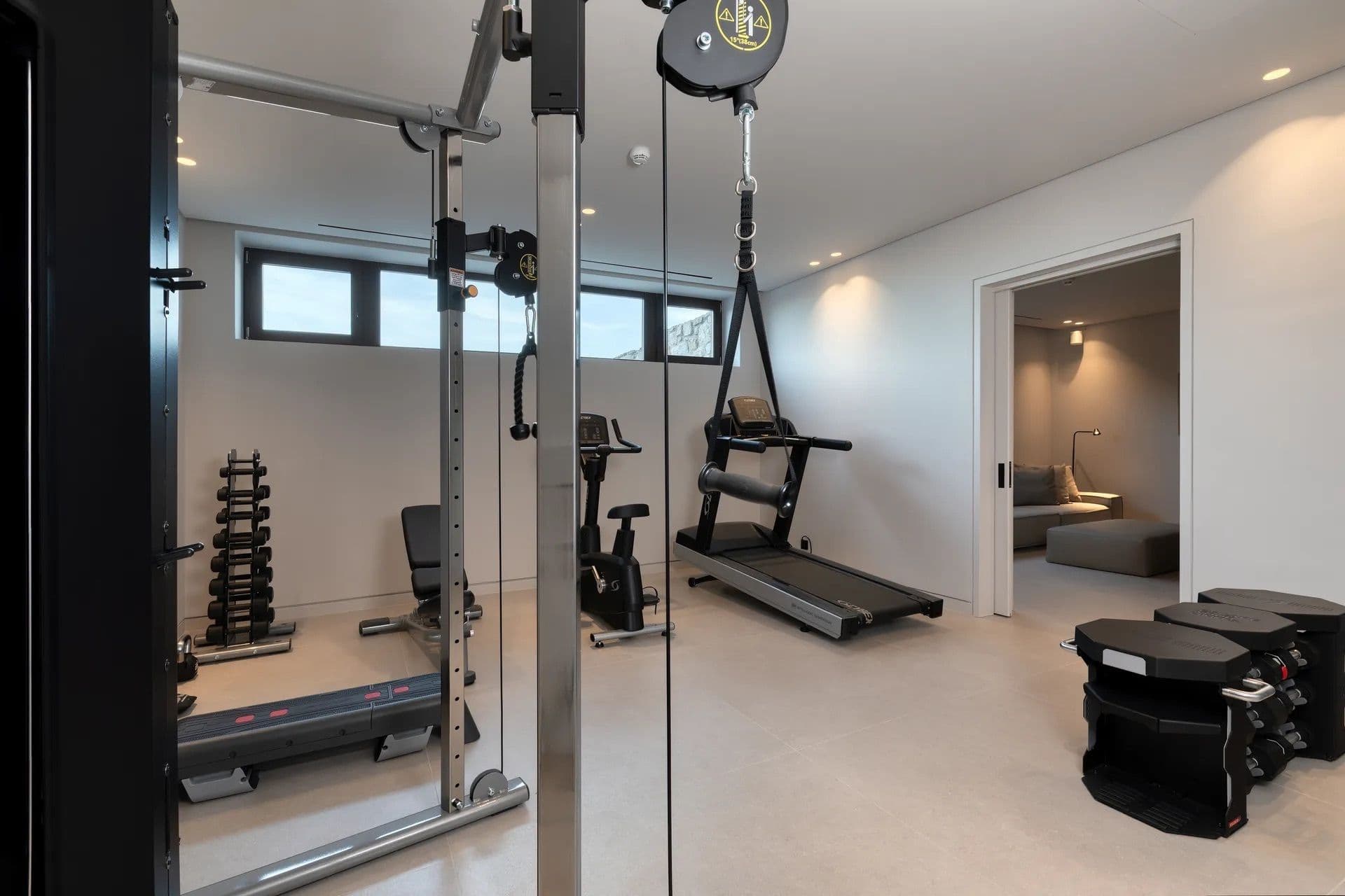 Home gym fitted with a treadmill, weights rack and cardio equipment