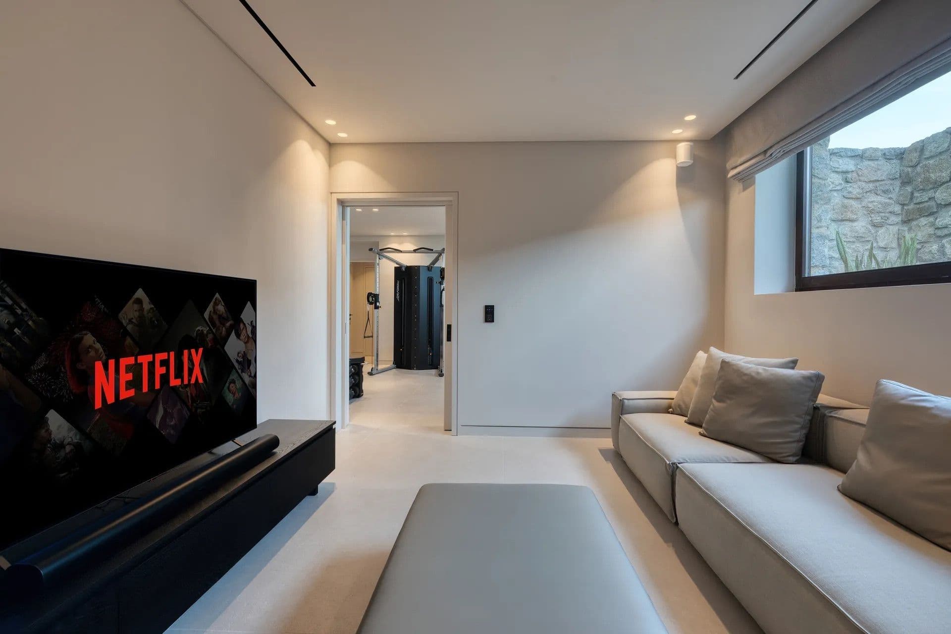 Media room with a large television and grey sectional sofa