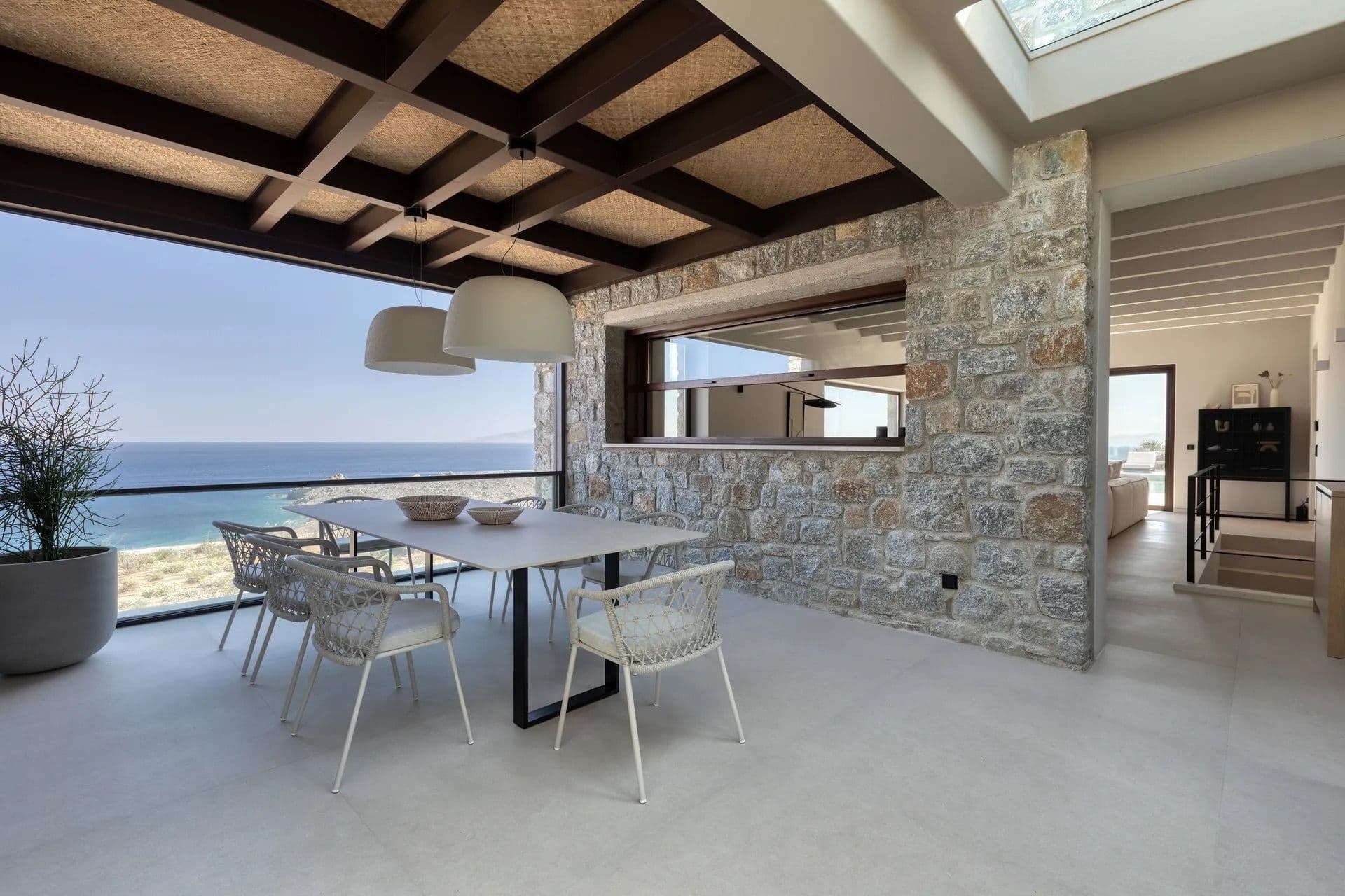 Outdoor dining table set beneath a pergola with sea views