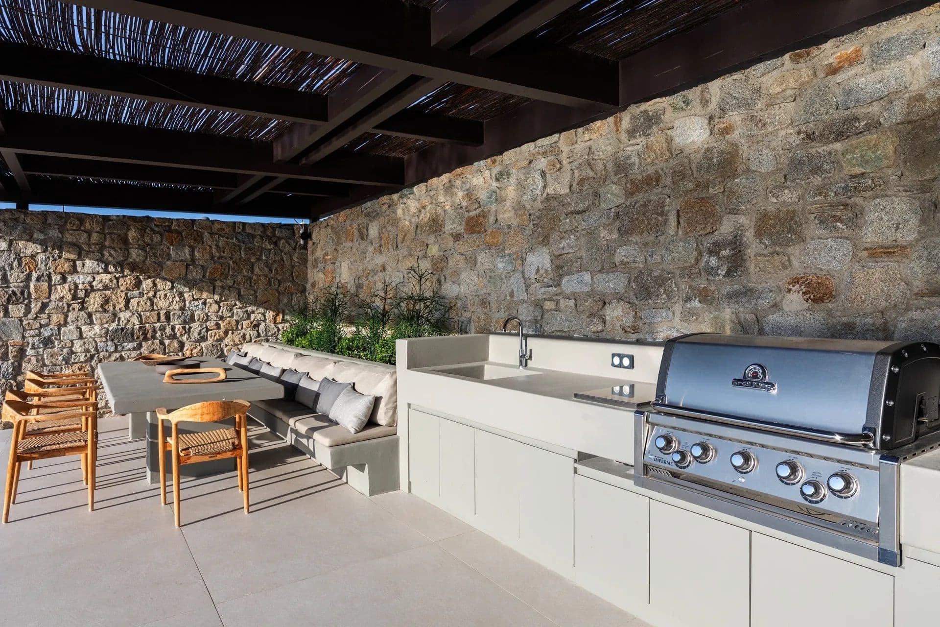 Covered outdoor kitchen with built-in barbecue and dining table