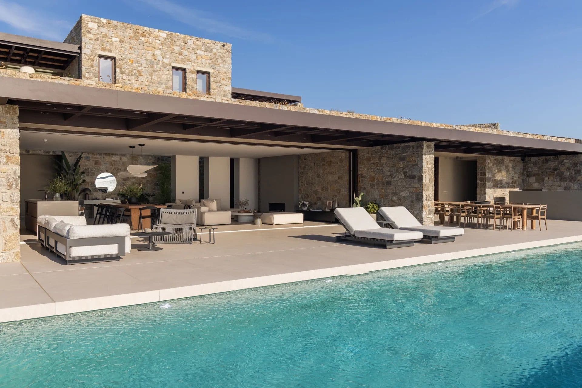 Aerial view of the stone-clad villa, pool and terraces set against the hillside