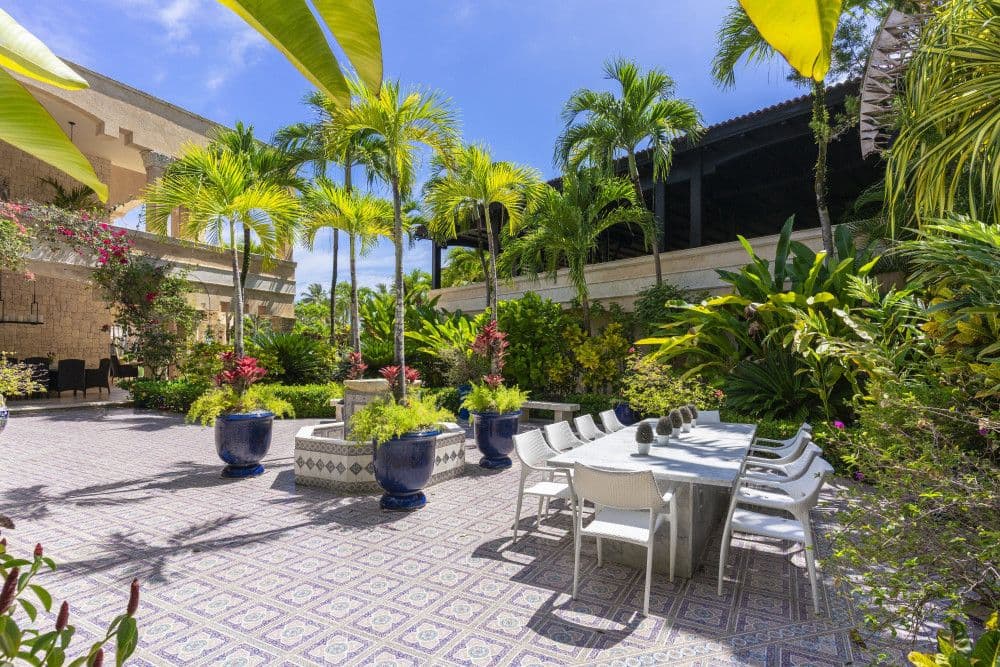 Courtyard dining terrace with patterned tiles and tropical planting