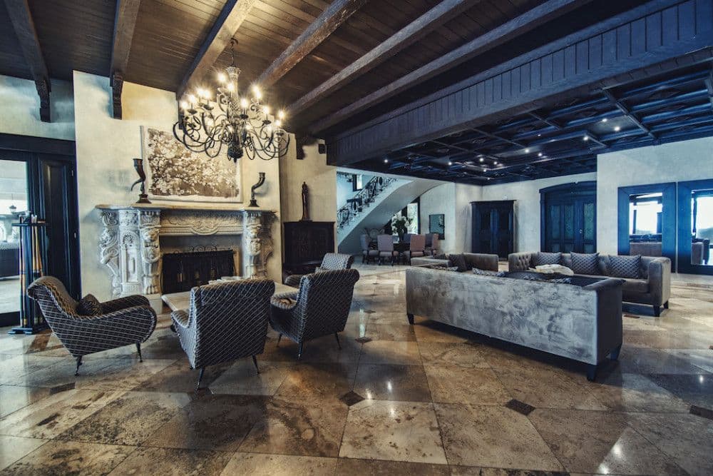 Formal lounge with a carved marble fireplace and velvet seating