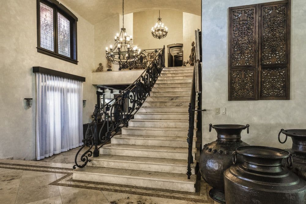 Marble staircase with a wrought-iron balustrade and stained glass