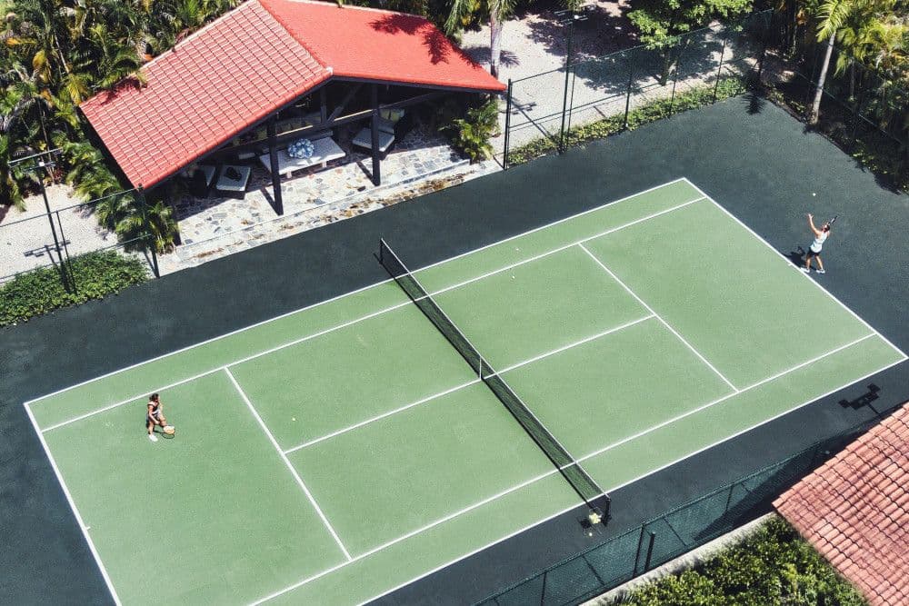Private tennis court with a shaded pavilion at Villa Anacaona