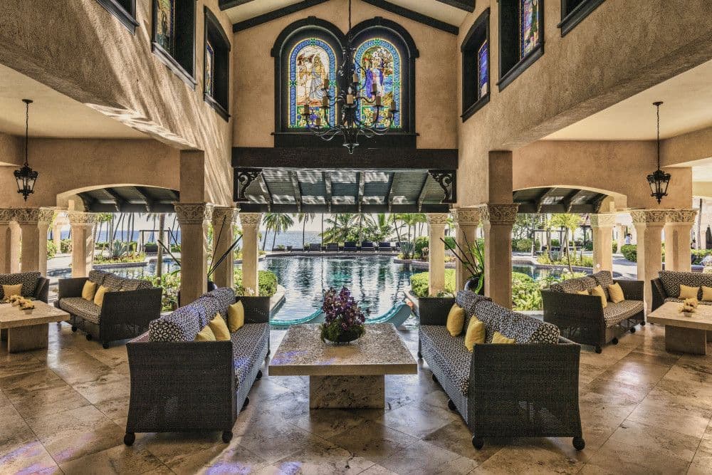 Covered terrace lounge with stained-glass window overlooking the pool and sea