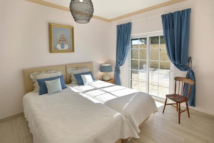 Double bedroom with blue accents and doors to the garden at Citrus, Peppers & Palms, Algarve