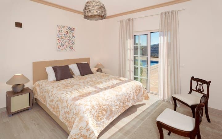 Double bedroom with a gold bedspread and doors to the pool at Citrus, Peppers & Palms, Algarve