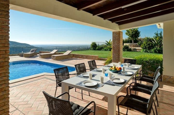 Covered terrace with an outdoor dining set beside the pool and hills at Citrus, Peppers & Palms, Algarve
