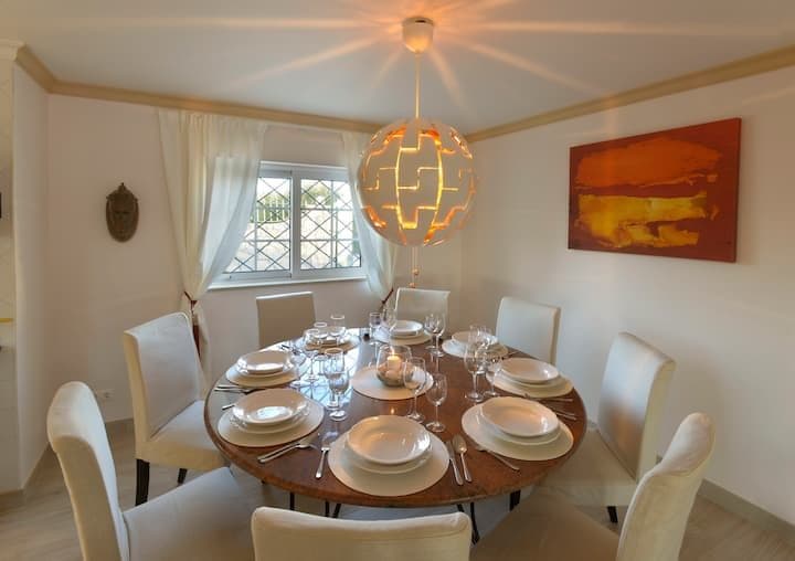 Dining room with a round table set for six under a pendant light at Citrus, Peppers & Palms, Algarve