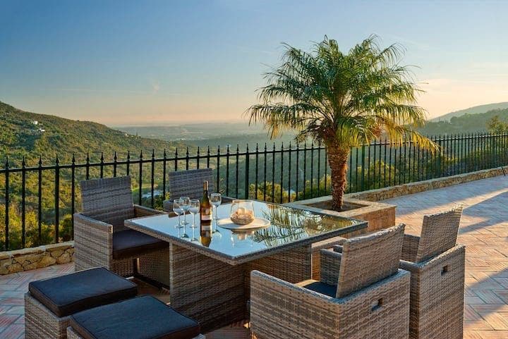 Outdoor dining table by a palm with a valley view at Citrus, Peppers & Palms, Algarve