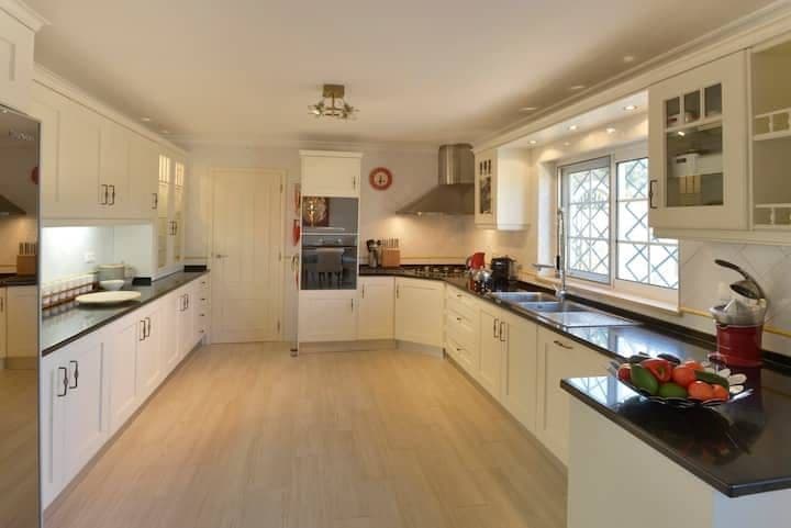 Cream kitchen with black granite worktops and a window over the hills at Citrus, Peppers & Palms, Algarve