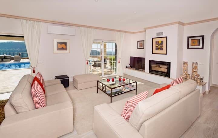 Sitting room with cream sofas, a television and a fireplace at Citrus, Peppers & Palms, Algarve