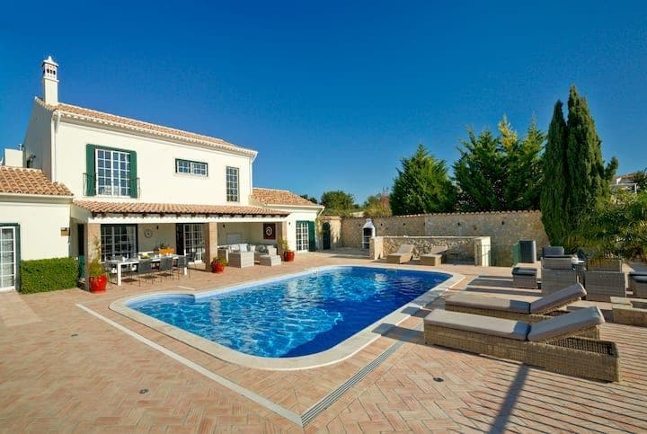 Swimming pool and sun loungers on a brick terrace beside the villa at Citrus, Peppers & Palms, Algarve