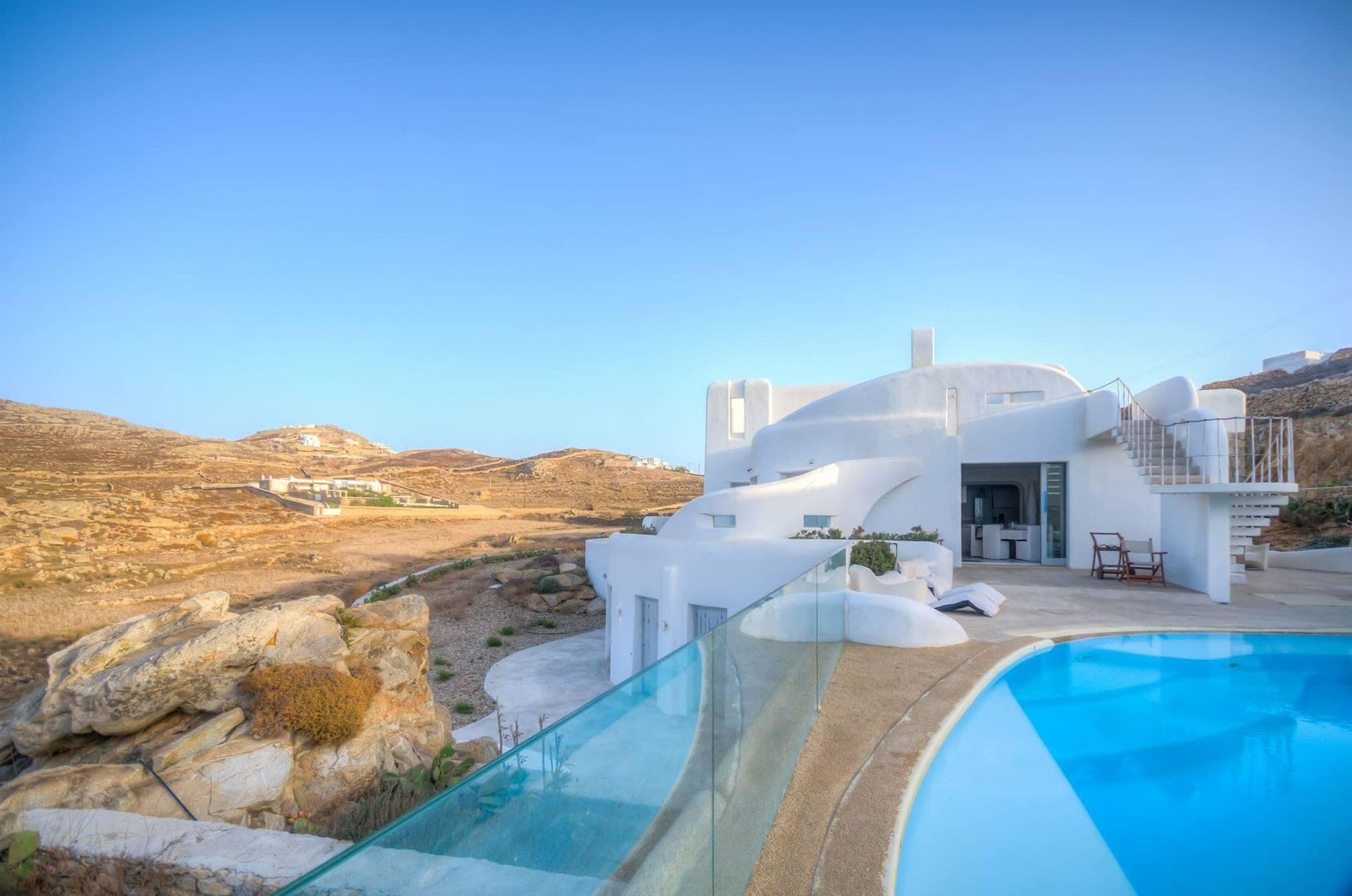 Sculptural white Mykonos villa perched above a cliffside pool overlooking the Aegean