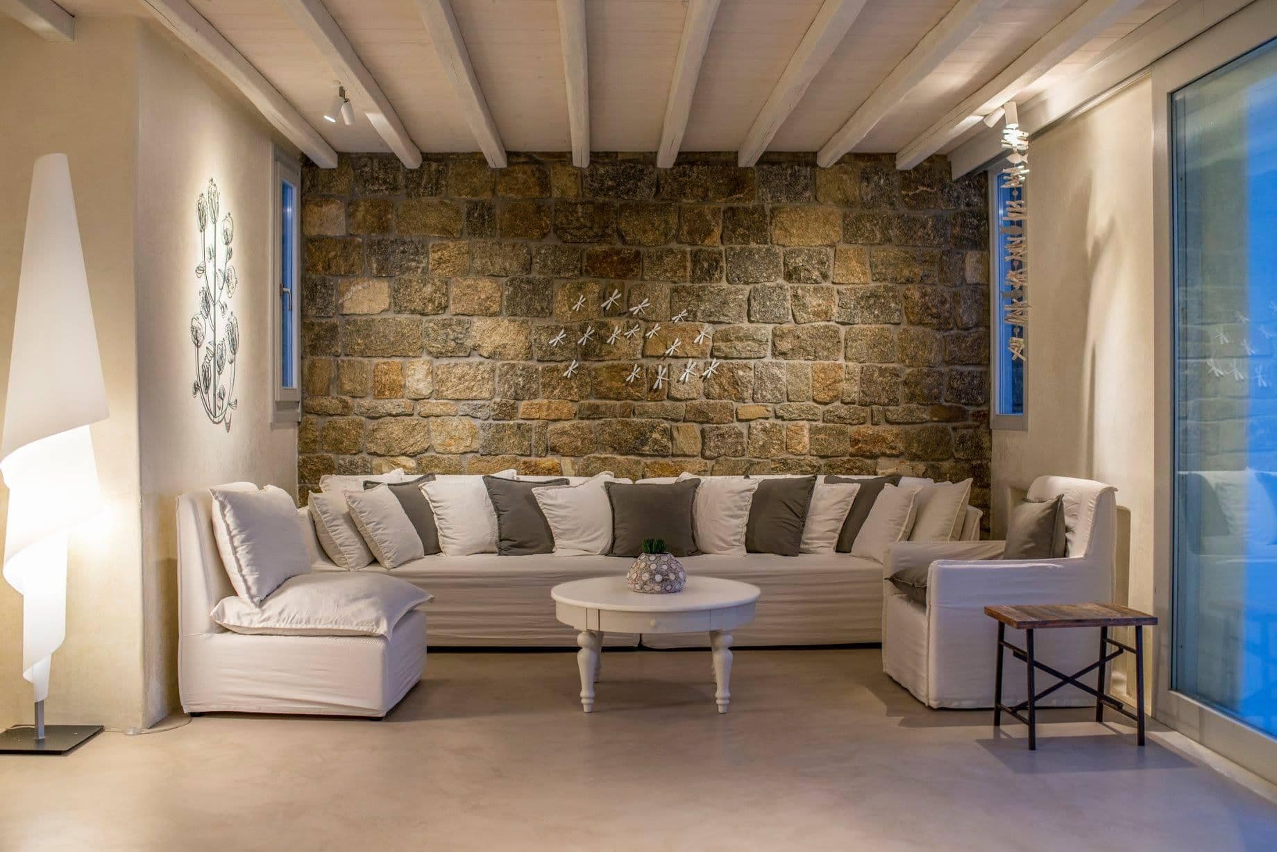Bright living room with white sofas and beamed ceiling