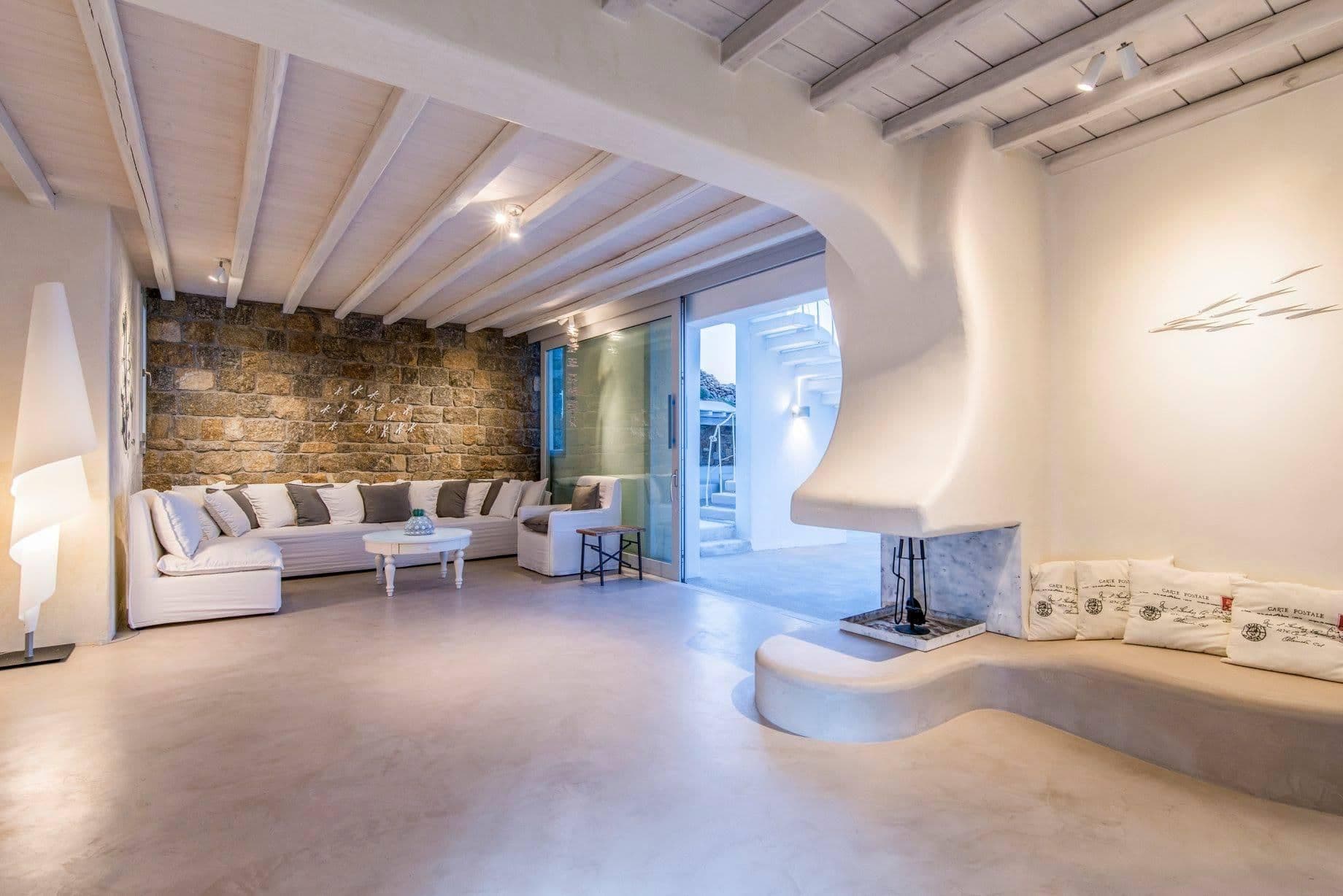 Curved white living room with built-in sofa and sculptural fireplace