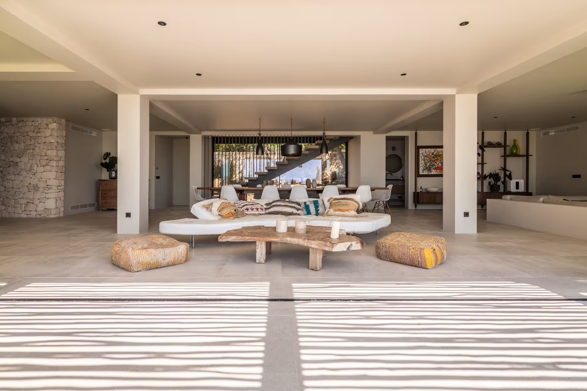 Open-plan living space with sculptural coffee tables and natural light