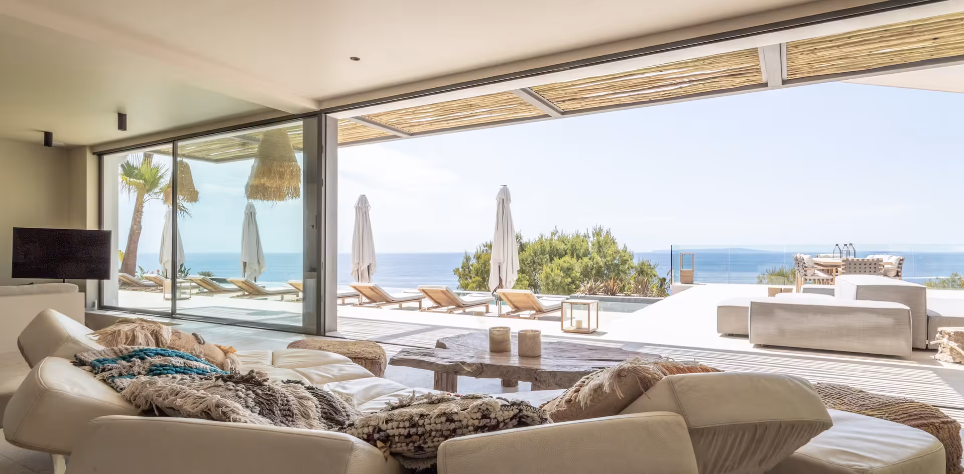 Living room with sliding glass doors opening directly onto the sea view terrace