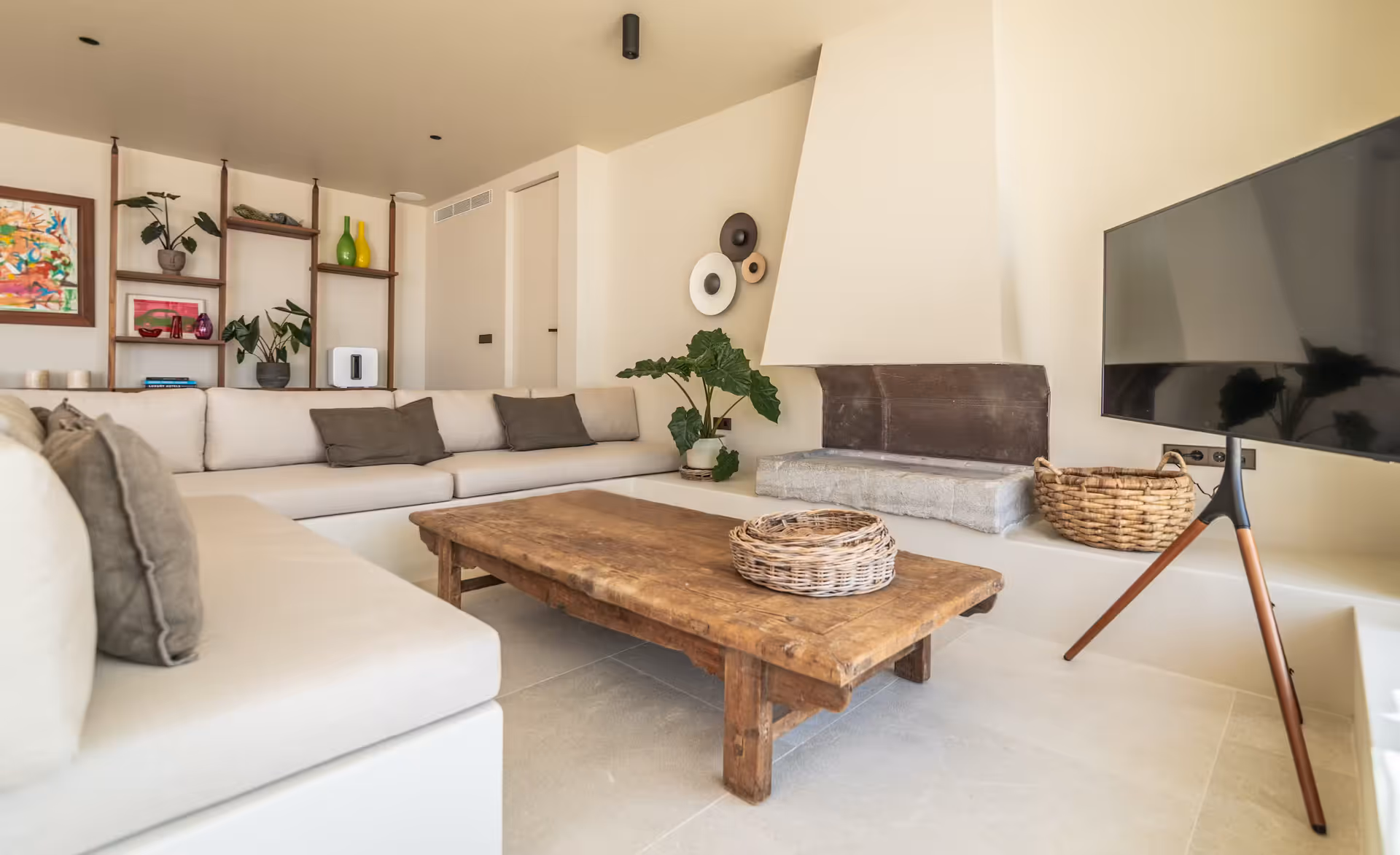 White L-shaped sectional sofa with patterned cushions and a reclaimed wood coffee table