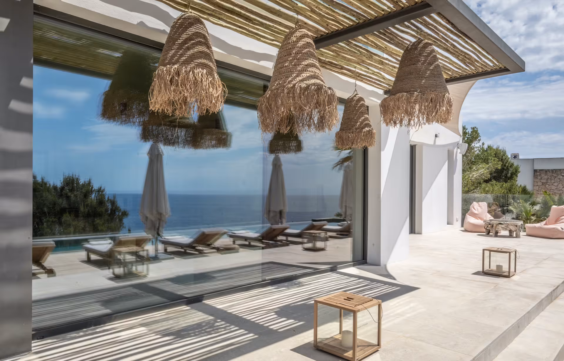 Covered terrace with fringed pendant shades opening onto the pool deck