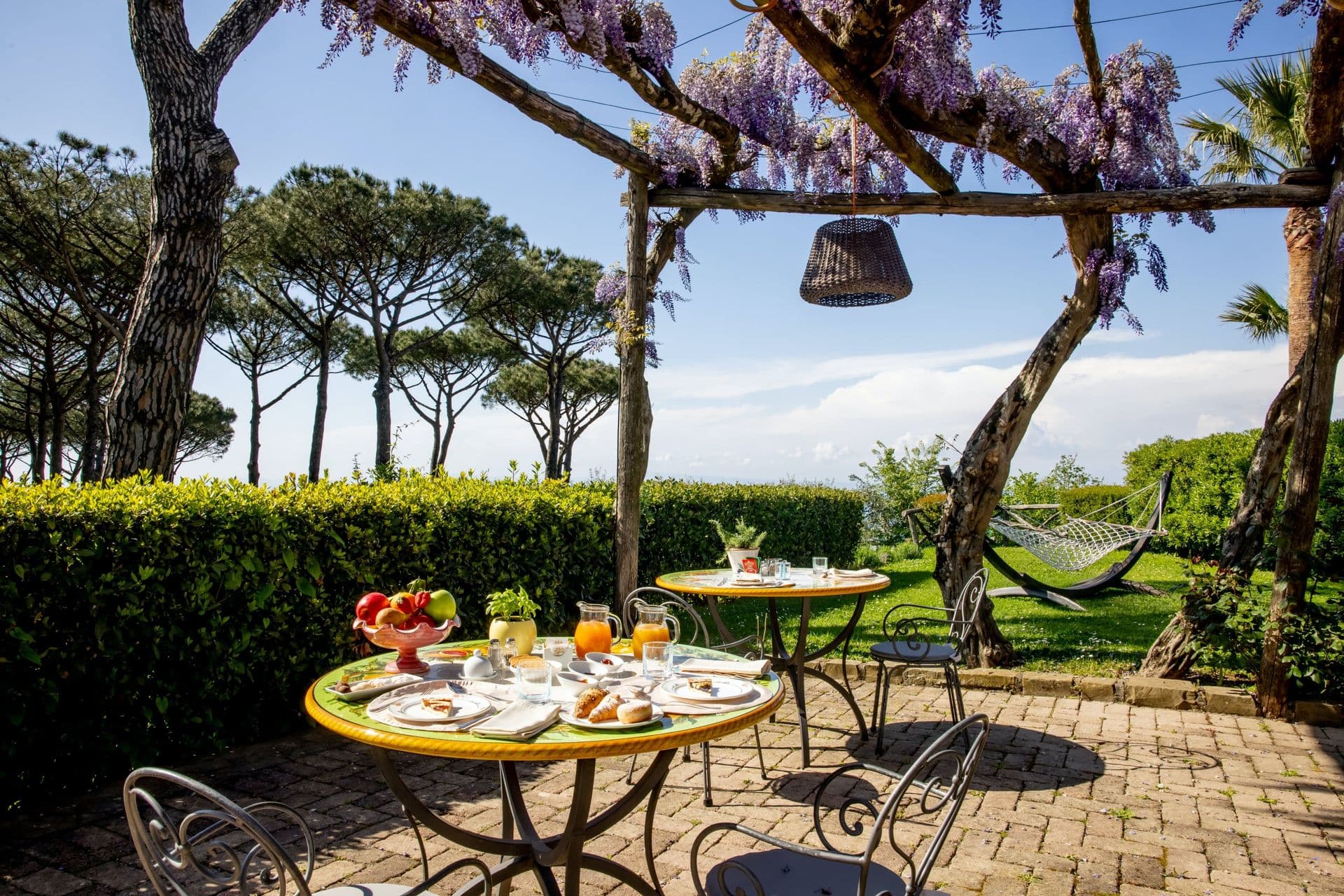 Breakfast laid out on a shaded garden terrace at Pavillion Paradiso