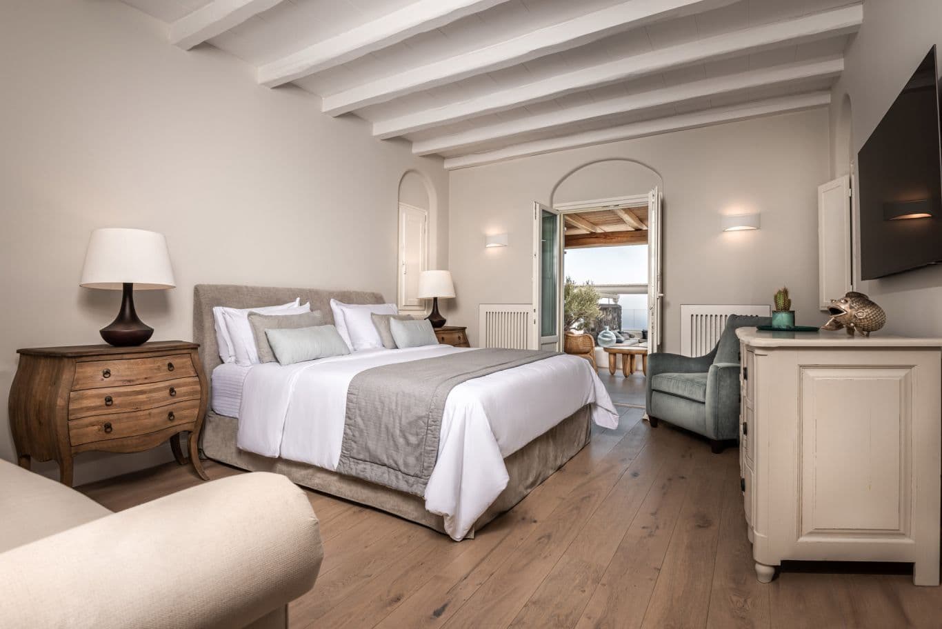 Bedroom with arched twin windows, cream tones and a sitting area
